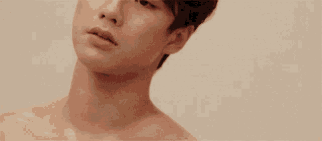 a young man without a shirt is looking at the camera