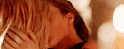 a woman is kissing another woman on the forehead .