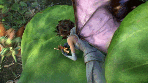 a fairy is laying on a green leaf holding a smaller fairy