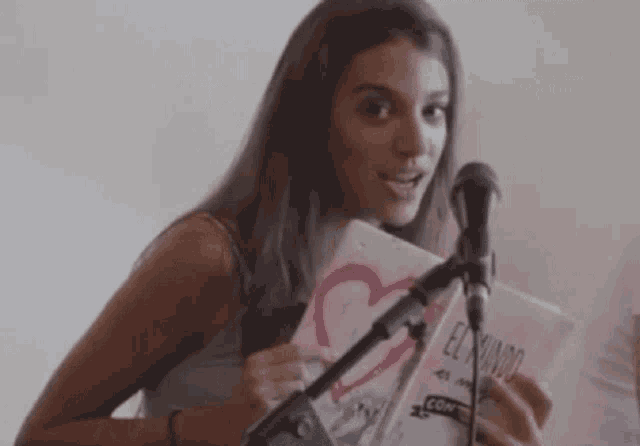 a woman is holding a book that says el mundo on it