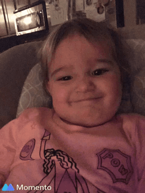 a little girl in a pink shirt that says momento on it