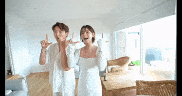 a man and a woman are standing in a living room .