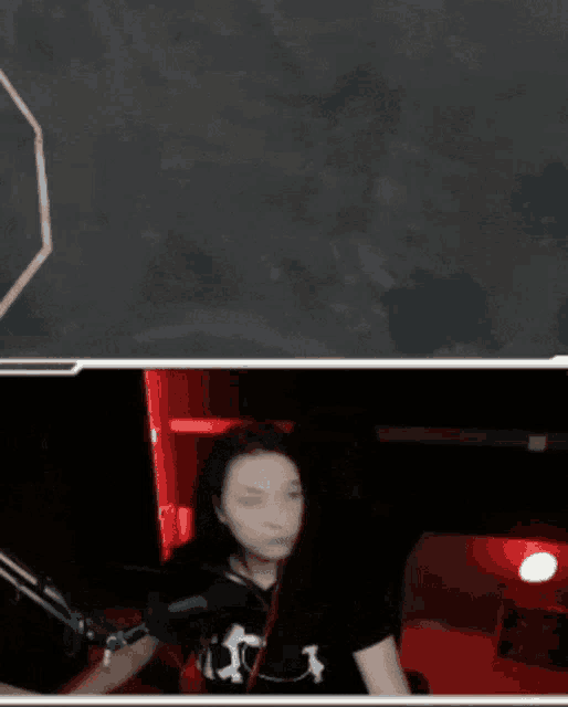 a woman is sitting in front of a microphone wearing a shirt that says ' skull ' on it