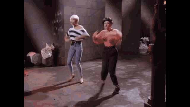 two women are dancing in a dark room .