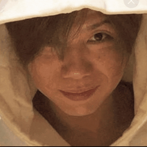 a close up of a woman 's face with a white hood on