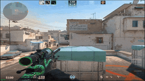 a screenshot of a video game with a green sniper rifle in front of a building with arabic writing
