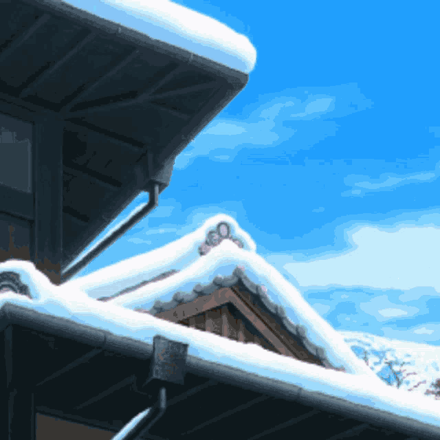 a snowy roof of a building with a blue sky behind it