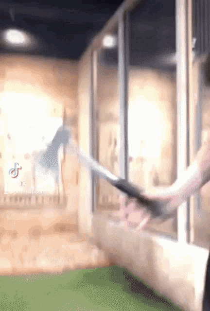 a person is holding a sword in their hand in front of a window in a room .