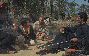 a group of people are sitting on the ground near a lake