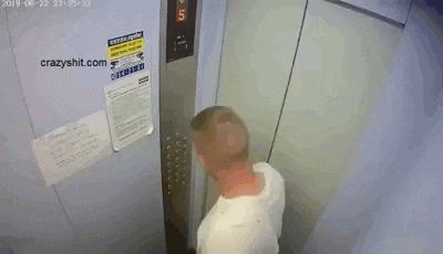 a man is standing in an elevator with a sign on the wall that says ' warning '