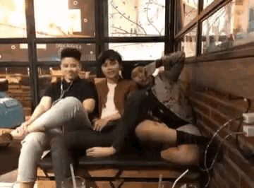 a group of people are sitting on a couch in a room .