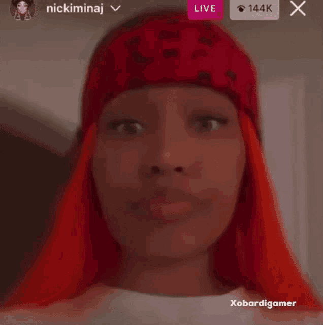 a blurry picture of a woman with red hair and a red hat .