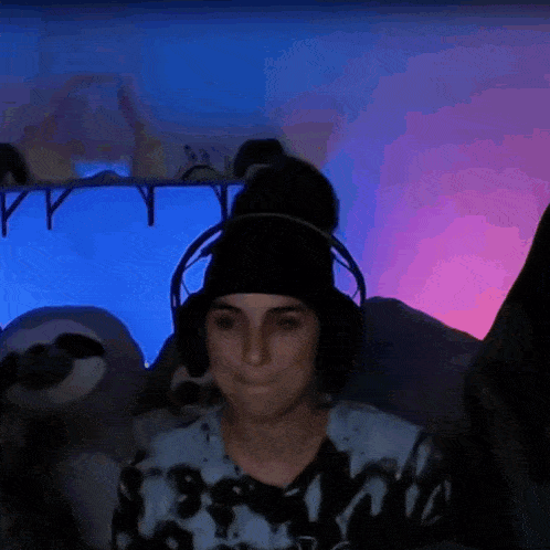 a woman wearing headphones is sitting in front of a stuffed animal .