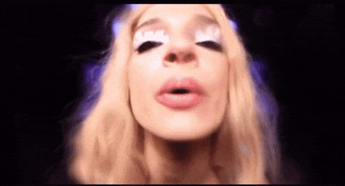 a woman with blonde hair is blowing a kiss