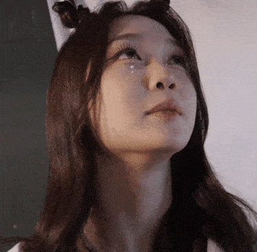 a close up of a woman 's face with tears coming out of her eyes
