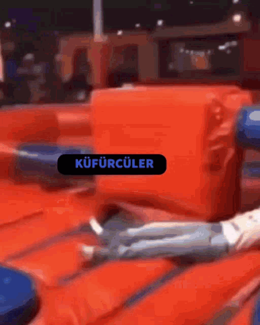 a person is laying on a red couch with a sign that says kufurculer on it