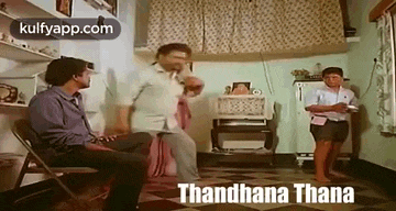 a group of men are sitting in chairs in a living room and dancing .