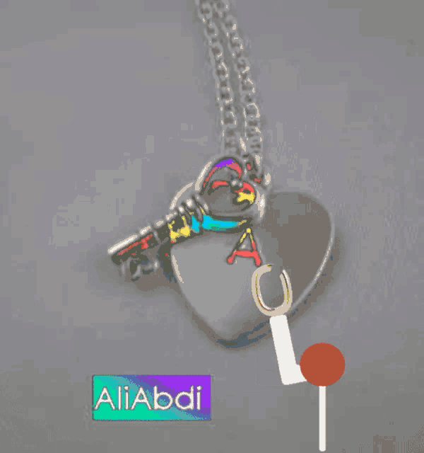 a necklace with a heart shaped pendant and a key with the letter l on it