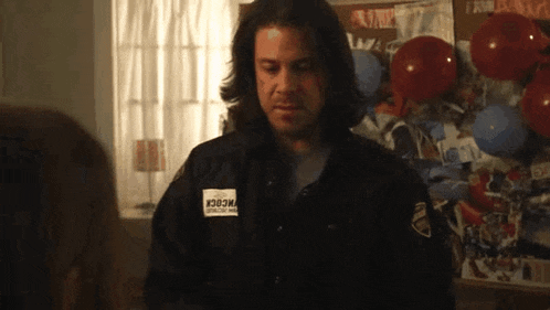 a man in a black jacket has a patch on his chest that says ' i30om ' on it