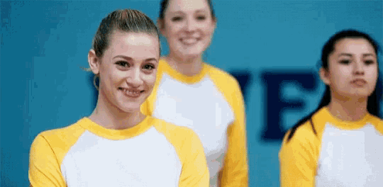 a group of girls are standing next to each other and smiling .