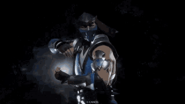 a man in a blue costume is standing in the snow with a light coming out of his hand .