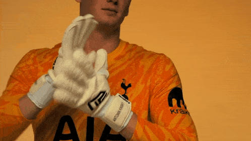 a man in an orange shirt holds a white object