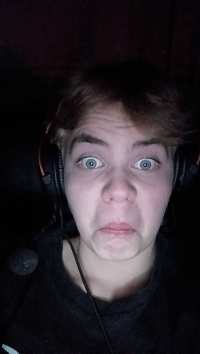 a young man wearing headphones is making a face