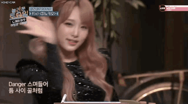 a girl with pink hair is on a tv screen with the words danger on it