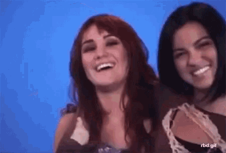 two women are standing next to each other and smiling for the camera .