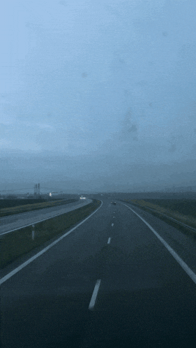 a blurred image of a highway with a blue sky in the background