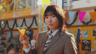 a woman in a suit is holding a martini glass