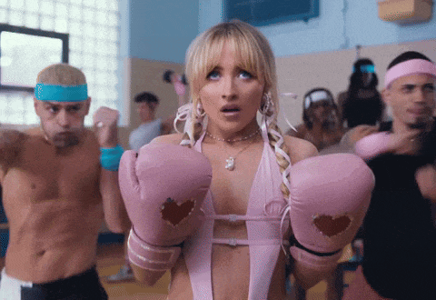 a woman wearing pink boxing gloves with a heart cut out