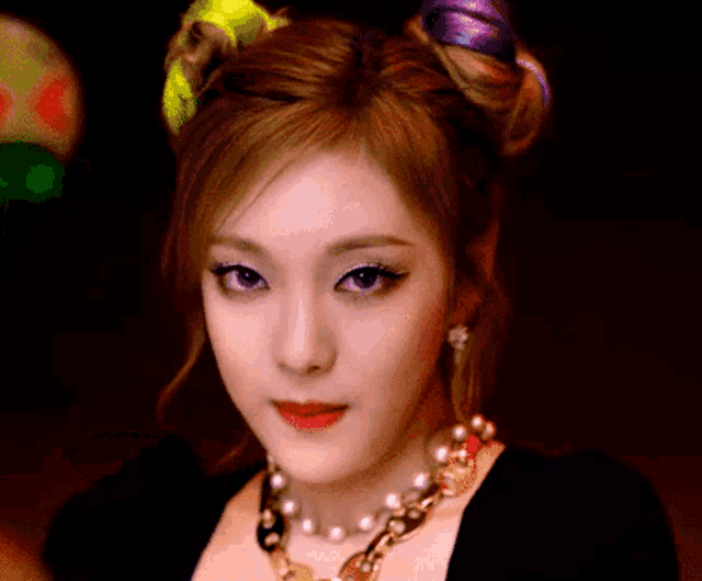 a close up of a woman 's face wearing a necklace and earrings