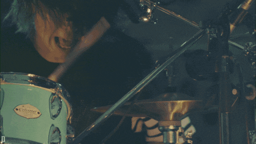 a person is playing a drum set with a label that says ' pearl ' on it
