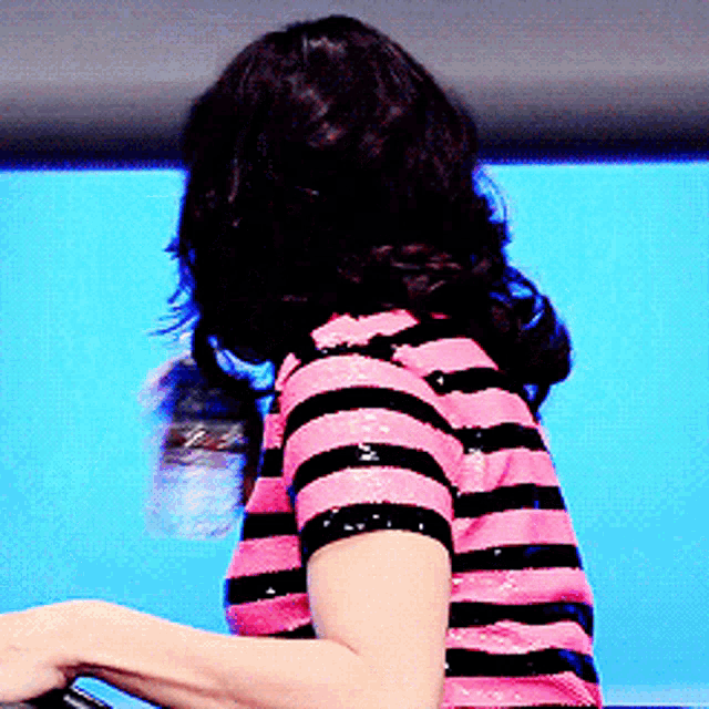 a woman wearing a pink and black striped shirt