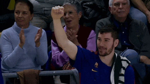 a man in a blue shirt is giving the peace sign