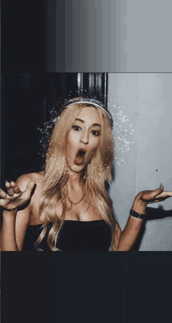 a blonde woman wearing a headband makes a funny face