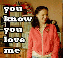 a woman in a pink jacket is standing in front of a bookshelf with the words " you know you love me " on it