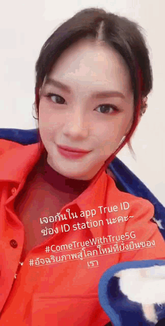 a woman is wearing an orange shirt and a blue jacket and has a sticker on her face that says true id