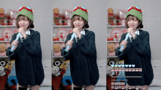 a girl wearing a green hat and goggles holds a microphone
