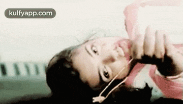 a woman is laying on her back with headphones on her ears .