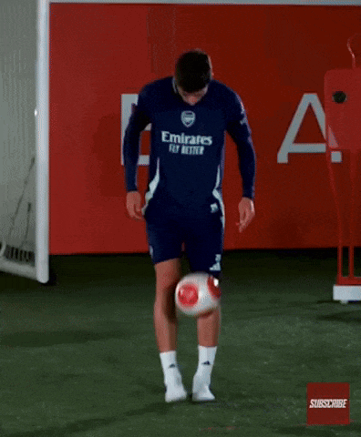 a man wearing a blue emirates fly better jersey is kicking a soccer ball