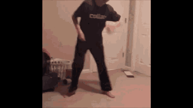 a person is dancing in a room with a laundry basket behind them