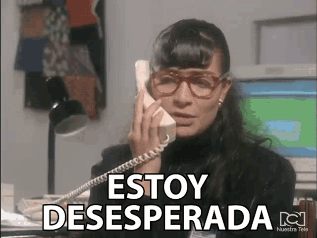 a woman wearing glasses is talking on a phone with the words estoy desesperada written below her