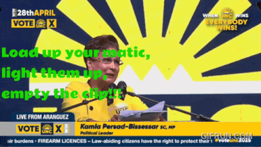 a woman is giving a speech in front of a sign that says vote unc x