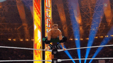 a man in a wrestling ring with a sign that says ' wwe ' on it