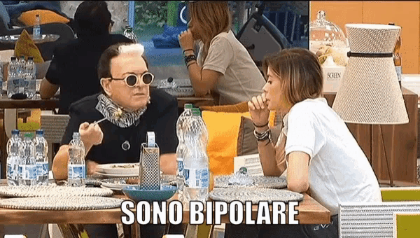 a man and a woman are sitting at a table with the words sono bipolare written above them