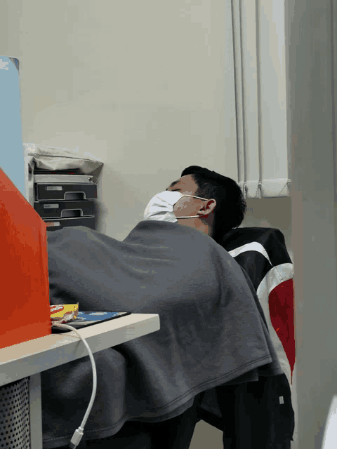 a man wearing a mask is sleeping on a chair