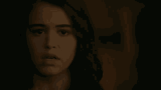 a close up of a woman 's face in the dark with a blurred background .