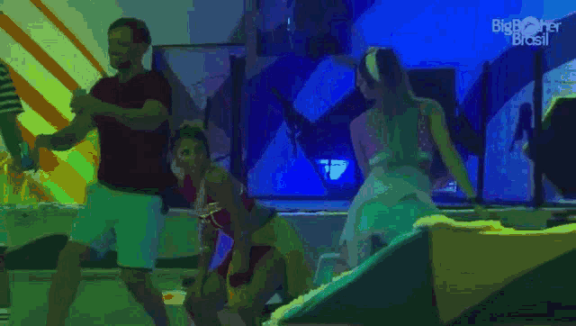 a group of people are dancing in front of a blue background that says big brother brasil